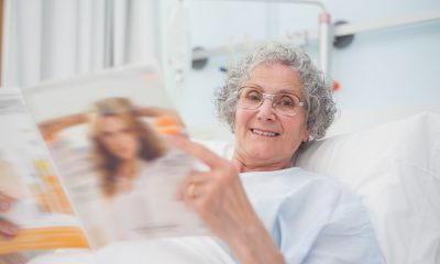 Patiente alitée lit un magazine